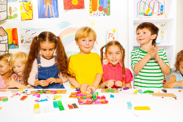 Fototapeta premium Happy boys and girls with plasticine in classroom