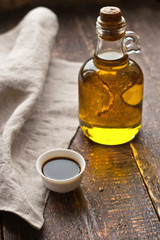 Olive oil in a glass bottle on the rustic table