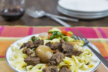 Greek beef stifado with roasted vegetables and egg noodles