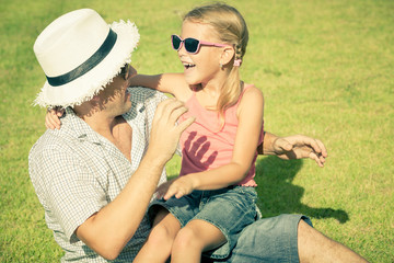 father and daughter playing on the grass at the day time