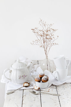 tea time with coconut sweets and dried flowers on white table