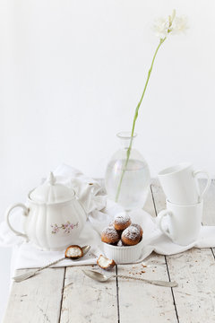 tea time with coconut sweets and tuberose flower on white table