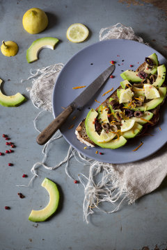 wholemeal vegan toast with avocado slices on plate with knife