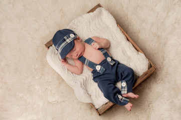 Newborn Baby Boy Wearing a Hat and Suspenders