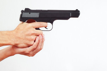 Hands with semi-automatic pistol on a white background