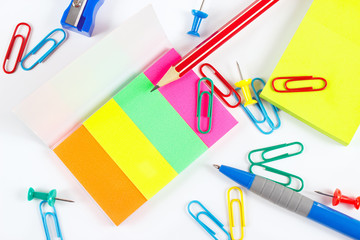 Multicolored office stationery on white desktop close up