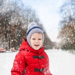 Happy boy in winter snowy park