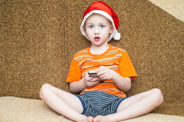 Boy using his smartphone while seated in front of the Christmas