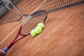  tennis racquet and balls on the clay tennis court 