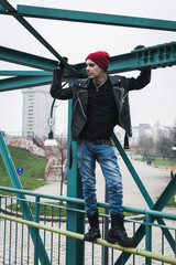 Punk guy standing on a bridge