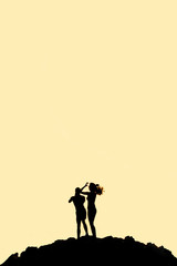 Naklejka premium Man and woman standing on mountain silhouette