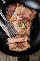 Жареный стейк из говядины на сковороде