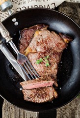 Жареный стейк из говядины на сковороде