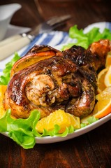 
Baked turkey leg with oranges on wooden background