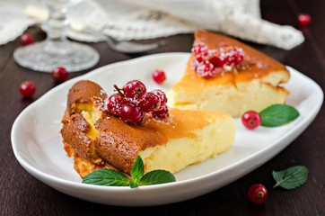 Cottage cheese casserole with freshly berries in white plate on wooden table