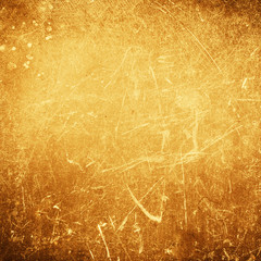 Abstract gold textured  background with spotlight and scratches.