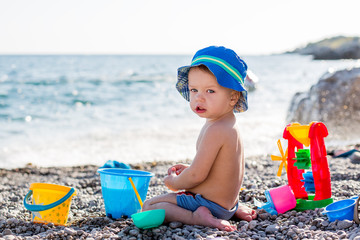 cute toddler boy playing on the beach