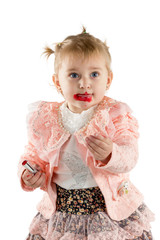 Little girl paints lips with lipstick