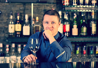 young man working as a bartender in a nightclub bar