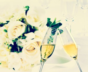 champagne flutes on wedding flowers background