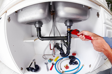 Plumber hands with a wrench.
