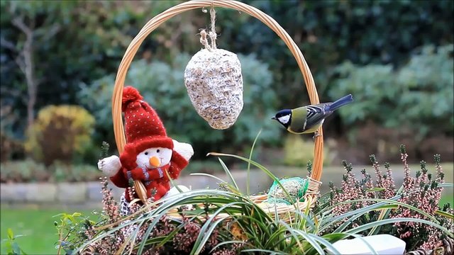 Korb mit Puppe und Winterfutter f&uuml;r V&ouml;gel 