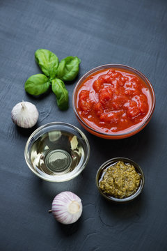 Chopped tomatoes, basil pesto, olive oil and garlic, close-up
