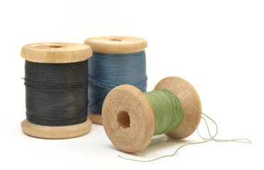 three wooden spools of thread