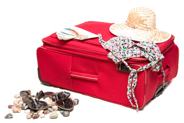 Красный чемодан с шляпой на белом фоне