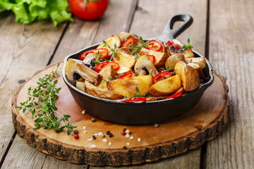 Fried potatoes with mushrooms in a frying pan