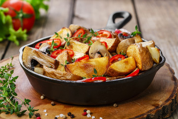 Fried potatoes with mushrooms in a frying pan