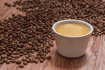 Cup of coffee and spilled coffee beans