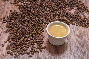 Cup of coffee and spilled coffee beans