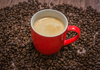 Cup of coffee and spilled coffee beans