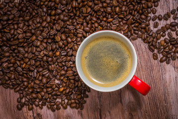 Cup of coffee and spilled coffee beans