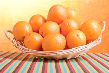 Beautiful ripe oranges on the table and a yellow orange backgrou