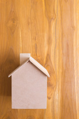 small wood house model on brown wooden background