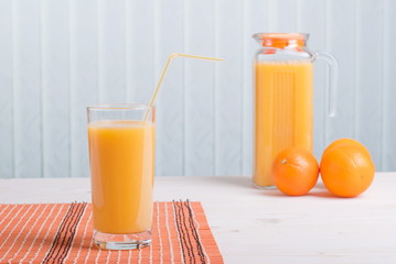orange juice beside delicious ripe oranges on the table