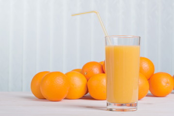 orange juice beside delicious ripe oranges on the table