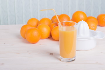 orange juice beside delicious ripe oranges on the table