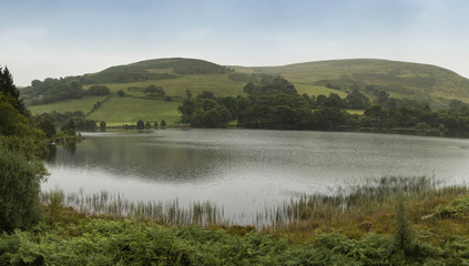 Landscape panorama of lake with rolling hills in background