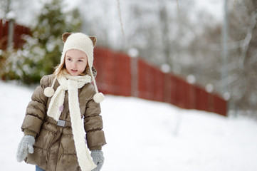 Adorable little girl having fun on winter day