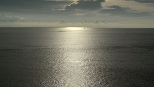light beam shining through the cloudscape over the sea