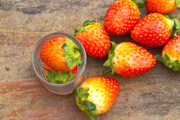 close up of fresh strawberries on the table and inside grass on