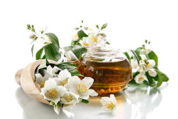 Obraz na płótnie Canvas jasmine tea in a teapot with a branch of jasmine