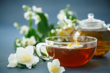 jasmine tea in a teapot with a branch of jasmine