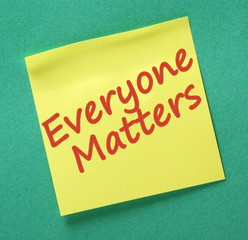 The phrase Everyone Matters written on a yellow sticky note