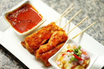 close up yellow indian fish satay in dish