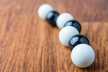 Naklejka na ściany i meble Black and white balls on wooden table
