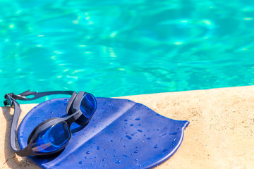 Fototapeta na wymiar cap and goggles on the edge of the pool